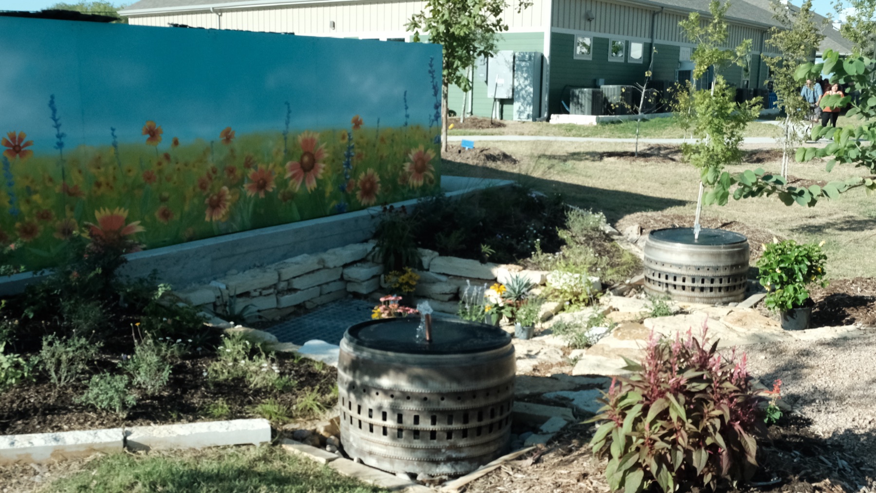 Fountains and a limestone-edged bioswale with native plantings and a Texas wildflower mural at Towne Twin Village